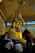 Applying gold leaf to statue at Mahamuni Pagoda, Myanmar 